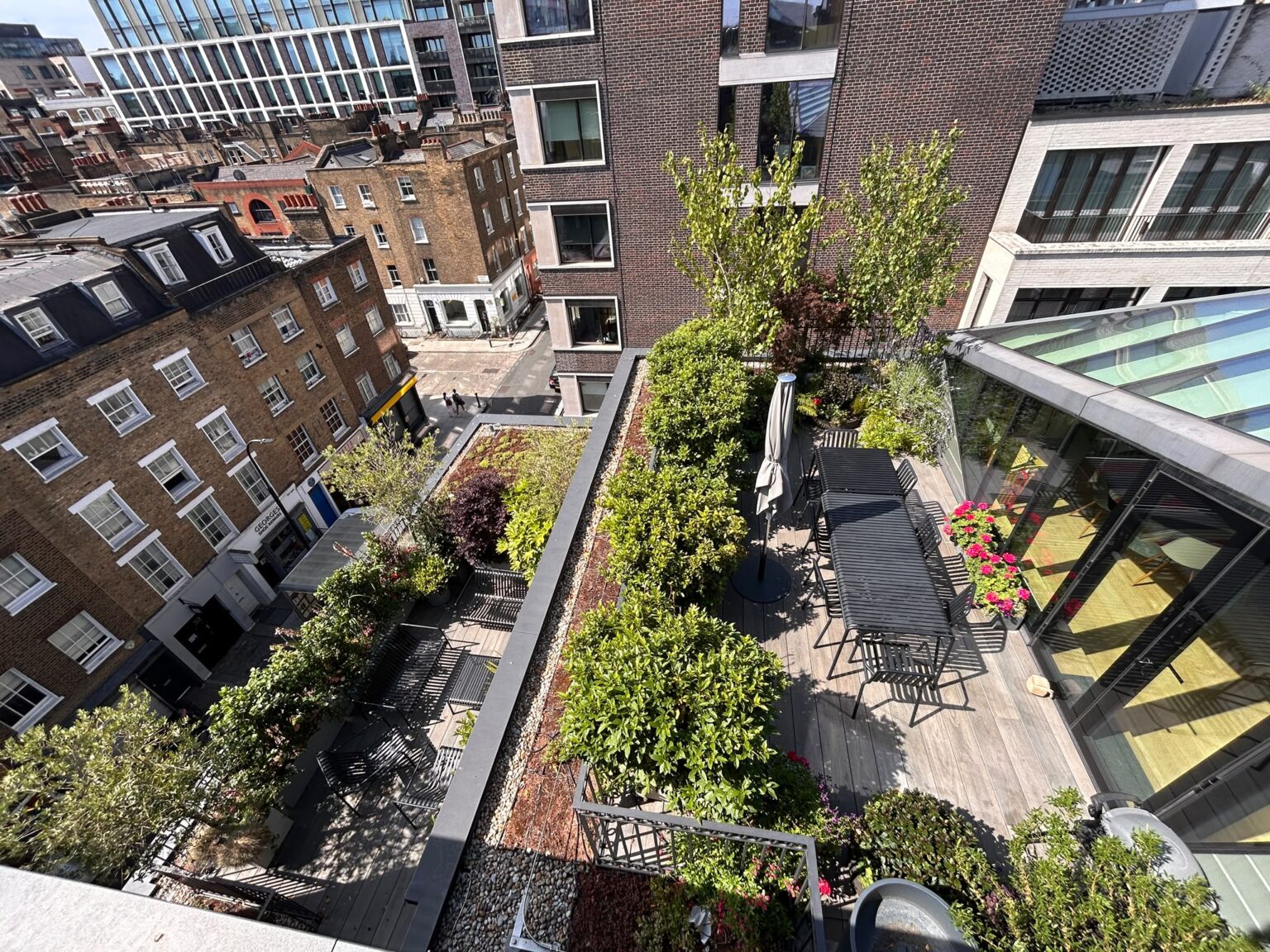 Layered rooftop terraces in central London with lush planting along the parapets
